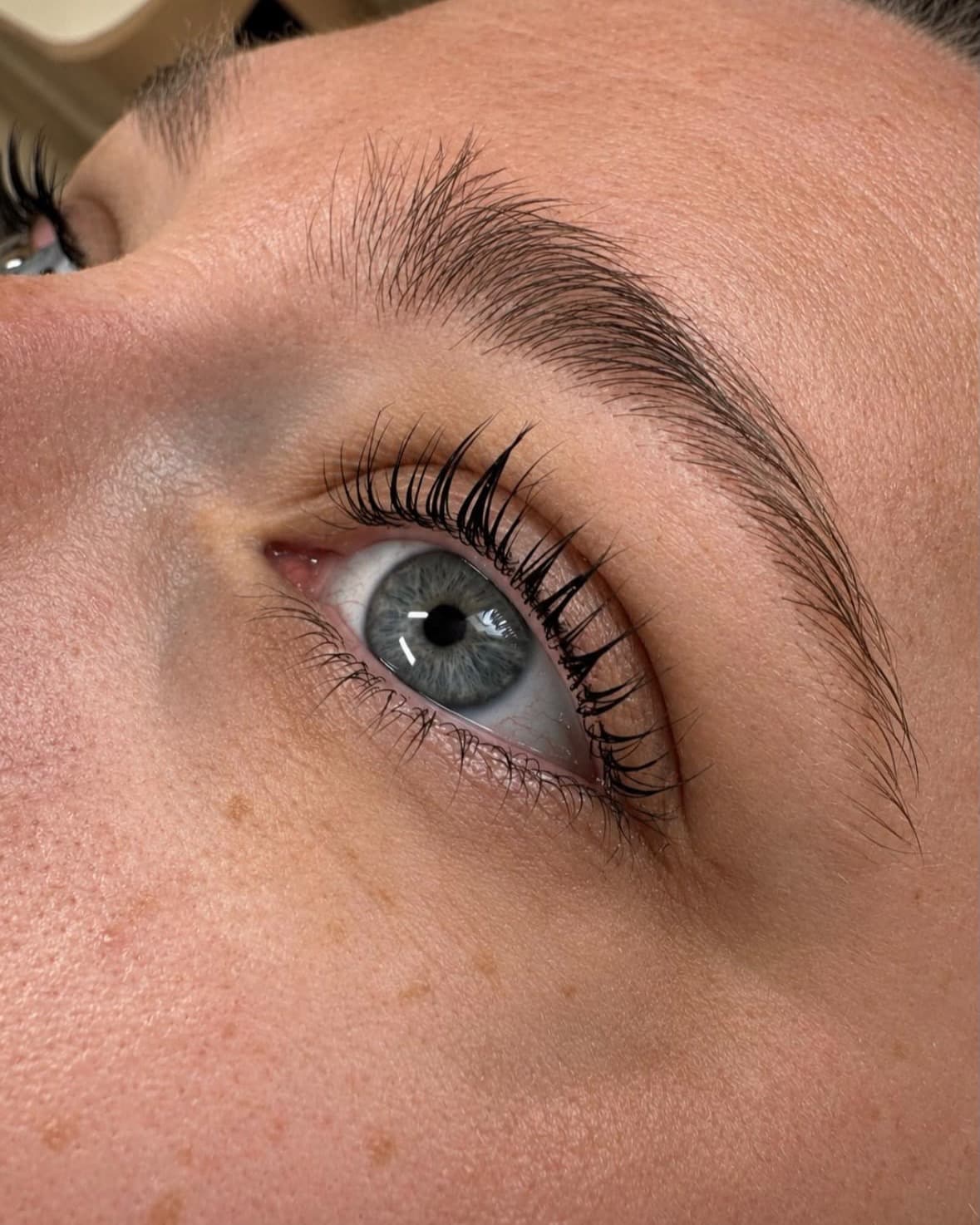 Œil bleu avec cils rehaussés et sourcil restructuré par un brow lift