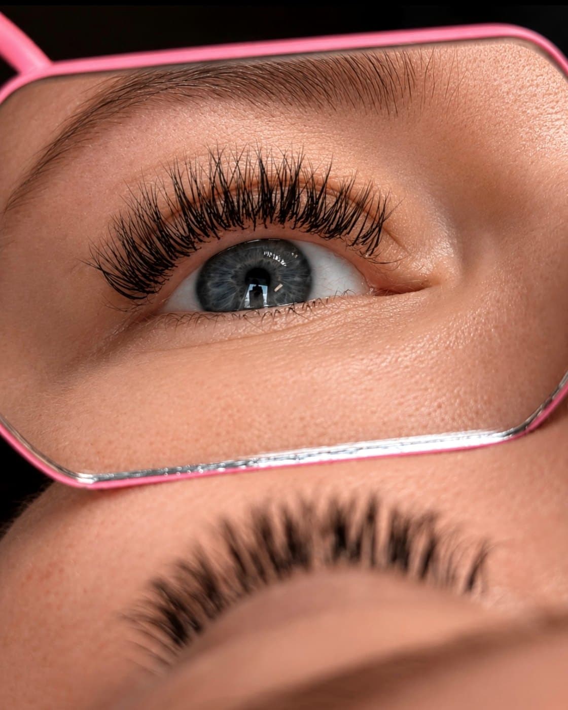Une cliente découvre ses extensions de cils dans un miroir, juste après la pose